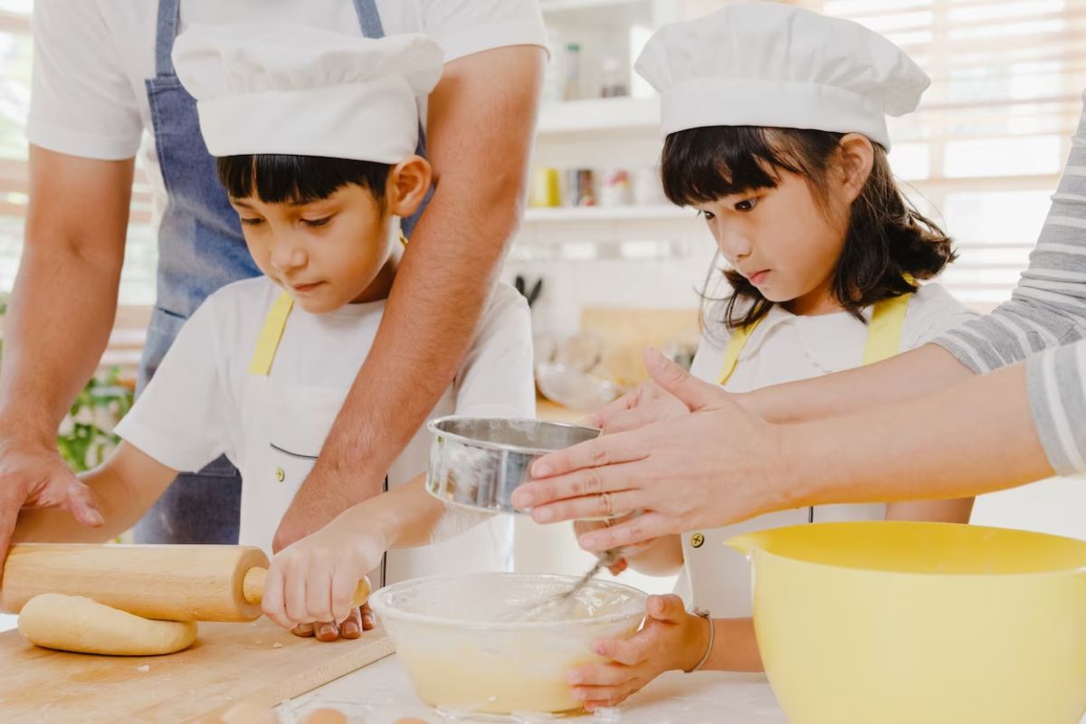 Two kids concentrating on a cooking class.